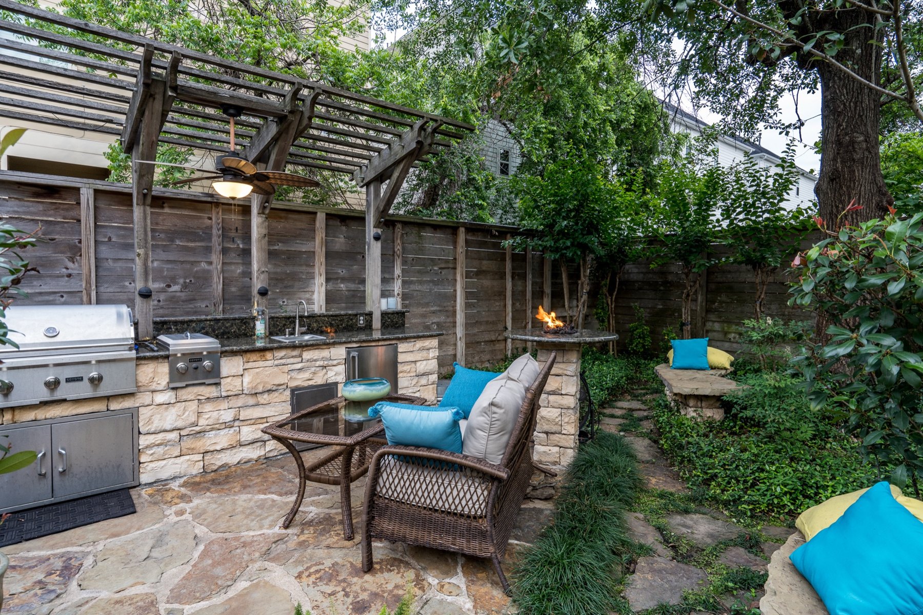 Backyard pergola with a grill and stone patio
